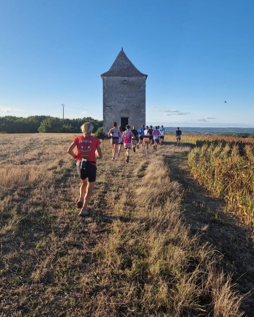 Coureurs du Trail Terroir Saussignac sur un chemin de chaume, vers un pigeonnier en pierre